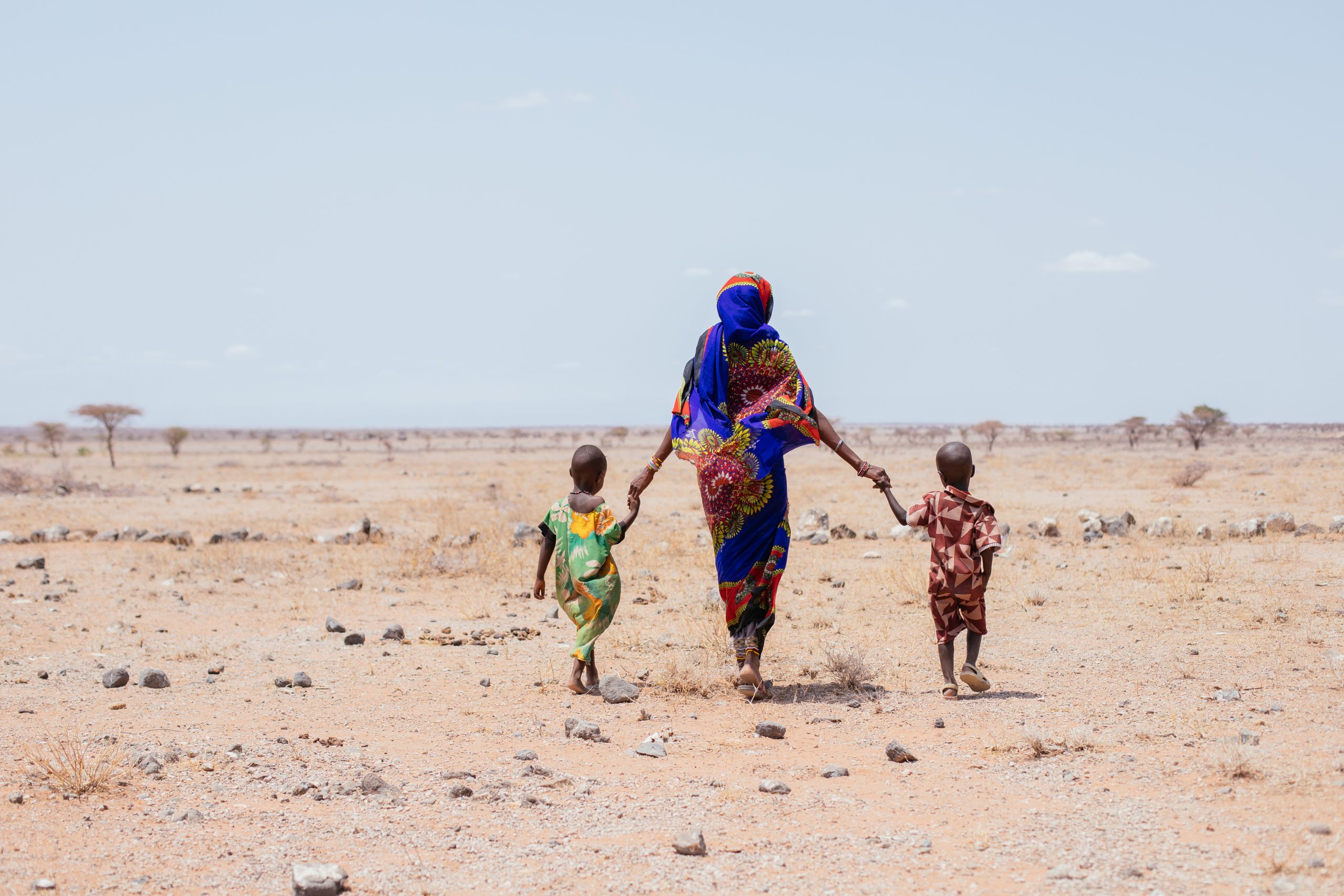 Ado från Kenya håller sina två söner i handen.